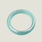 Teal jade ring on a gray background